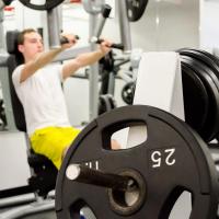 Student in yellow shorts training in the weight room